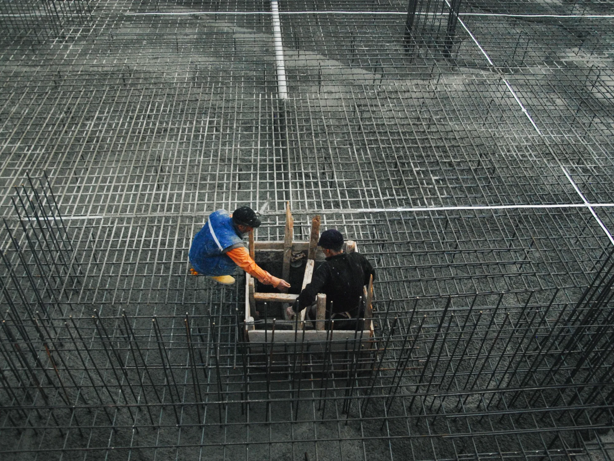 Trabajadores sobre una retícula de acero estructural, fotografía de referencia
